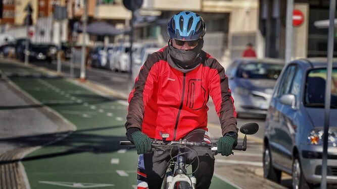 Un ciclista, muy abrigado en Cádiz.