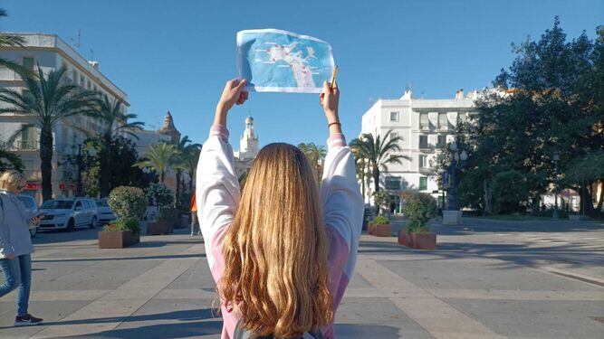 Una alumna muestra un mapa frente a la plaza de San Juan de Dios.