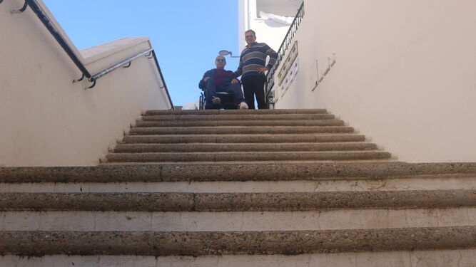 Paco González, en la silla de ruedas que utiliza, junto a su hermano Manuel, en la calle Malagueñas