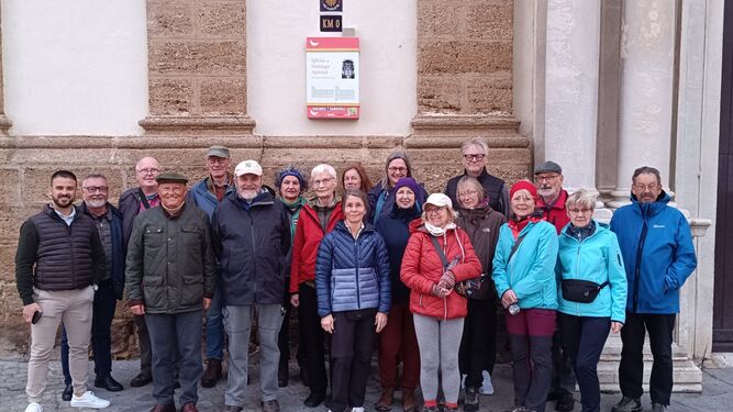 El grupo de peregrinos en la iglesia de Santiago, ante el kilómetro cero de la Vía Augusta, junto a responsables de la asociación gaditana.