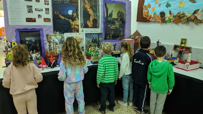 Alumnos del Juan Díaz de Solís miran las obras expuestas en la exposición de pasos de Semana Santa.