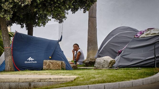 Una persona sin hogar, en una zona con varias tiendas de campaña, en una imagen de archivo.