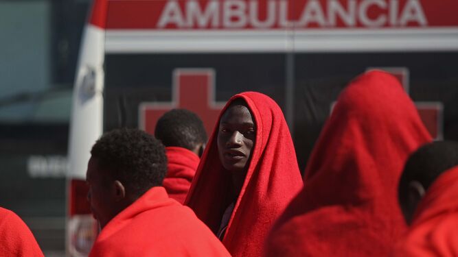 Migrantes recién rescatados de una patera y atendidos por Cruz Roja en el puerto de Tarifa.
