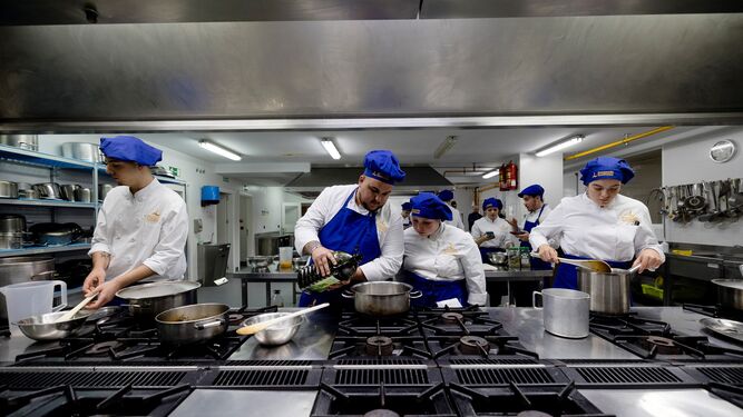 Varios alumnos de primero de Cocina y Gastronomía preparan la comida durante su clase práctica.