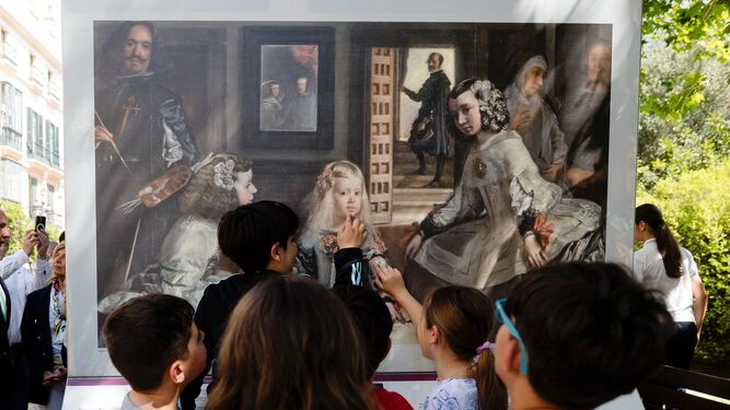 Un grupo de escolares se acercan a 'La familia de Felipe IV (Las meninas)' en la exposición en Cádiz de 'El Prado en las calles'.