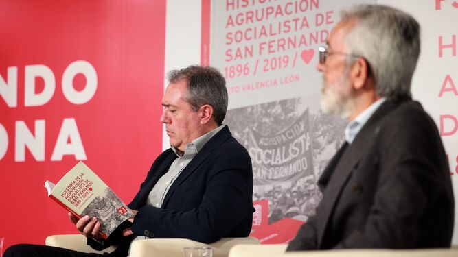 Juan Espadas hojea el libro sobre la historia del PSOE de San Fernando. A su lado, el autor, Tito Valencia.
